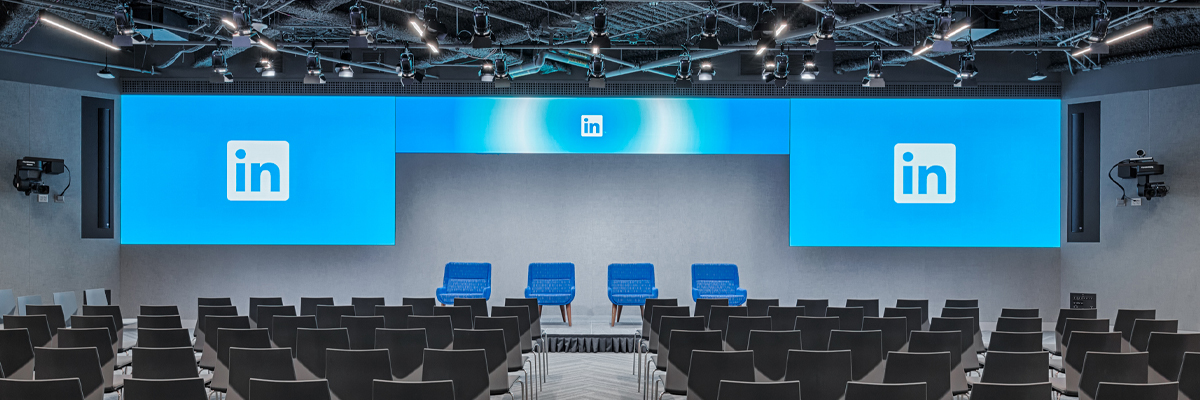 LinkedIn企业园区内的一个大会议室，里面有几排椅子和一个显示企业徽标的大屏幕